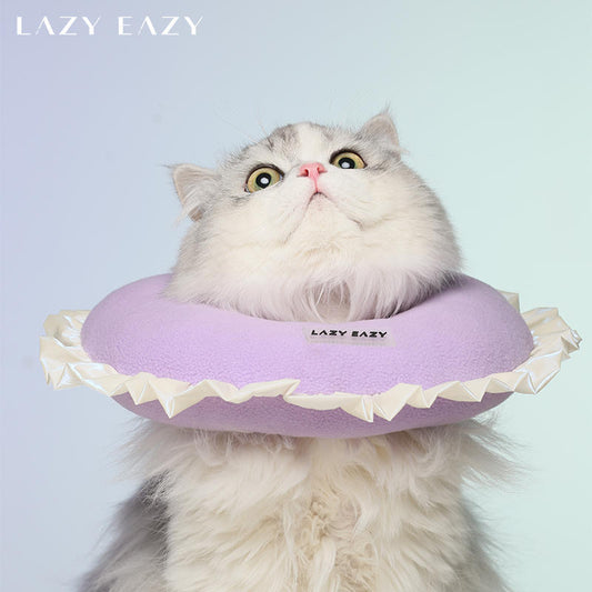 A cat wearing a donut shaped post-surgery recovery collar with ruffles