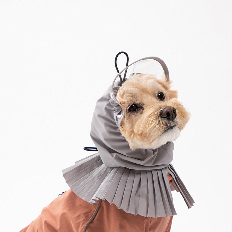 Poodle dog model in a pink raincoat with grey hood profile view